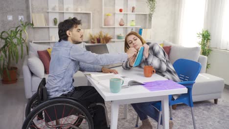 At-home-the-disabled-man-and-his-girlfriend-are-studying-for-lessons.-Studentship.